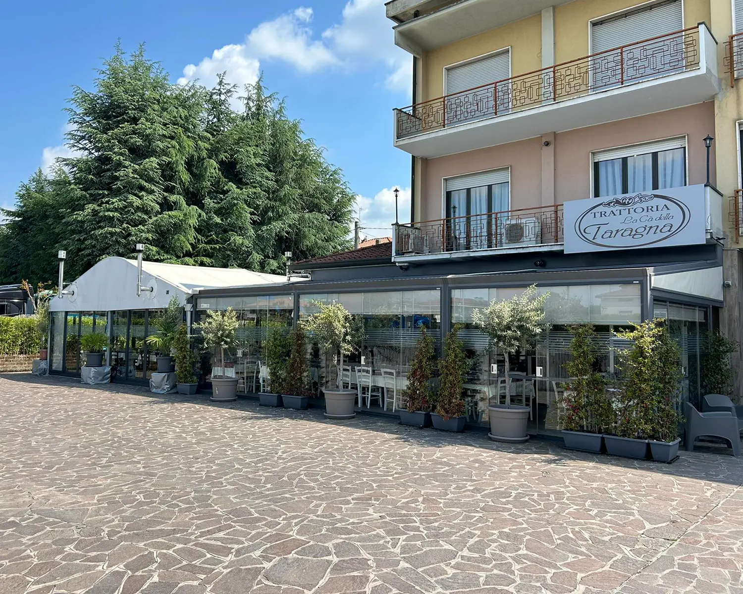 Man in apron stands in rustic kitchen, hands dusted with flour.