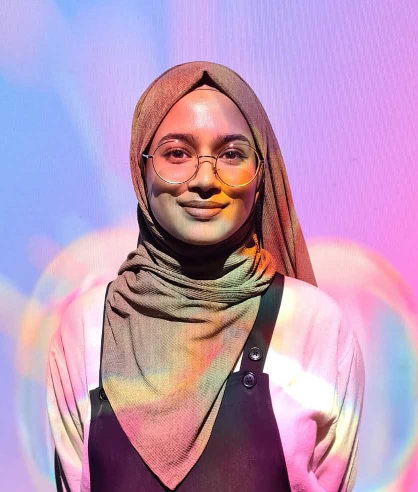 a picture of me, a woman wearing hijab against a colourful, abstract background