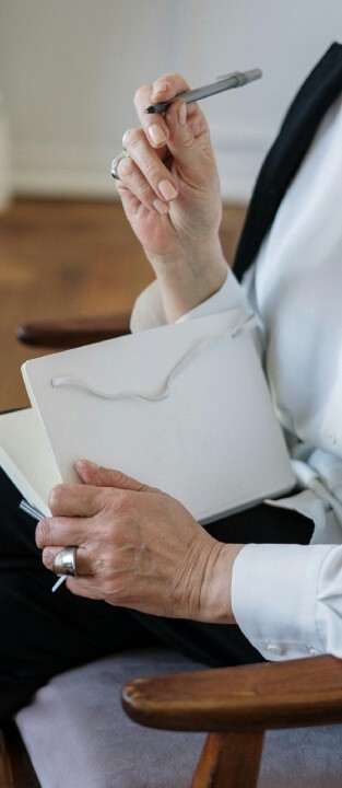 A person holding a pen and notebook