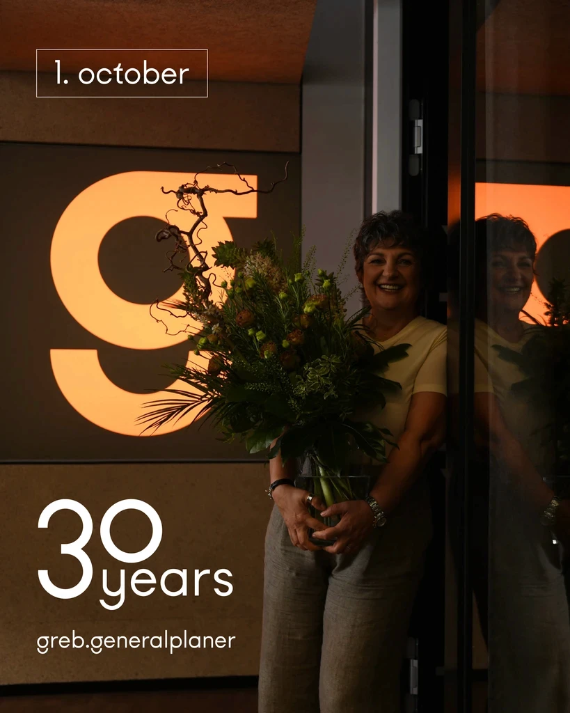 Frau steht mit Blumen in der Hand an Wand