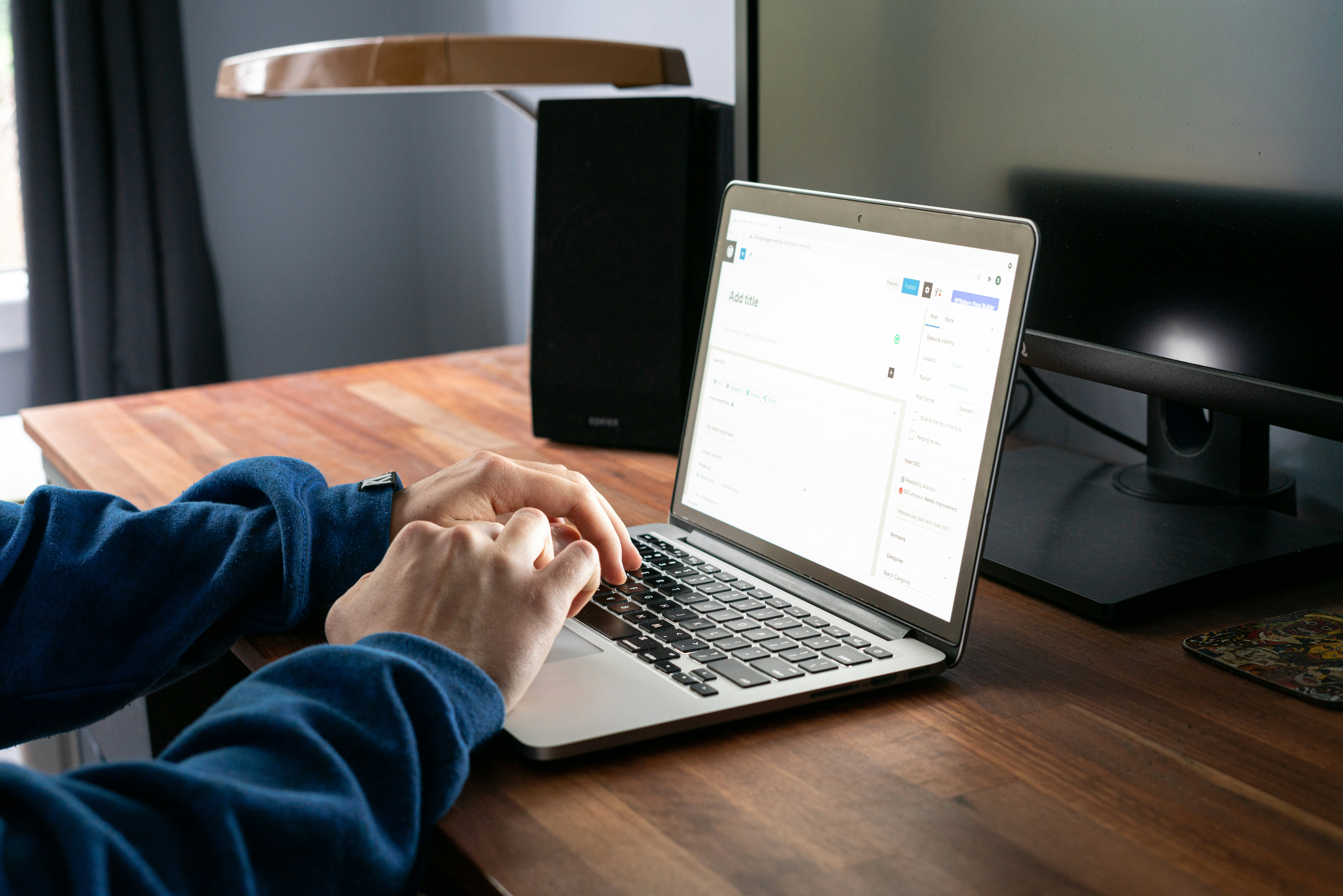 Person using a laptop at a desk to manage an online account or digital form.