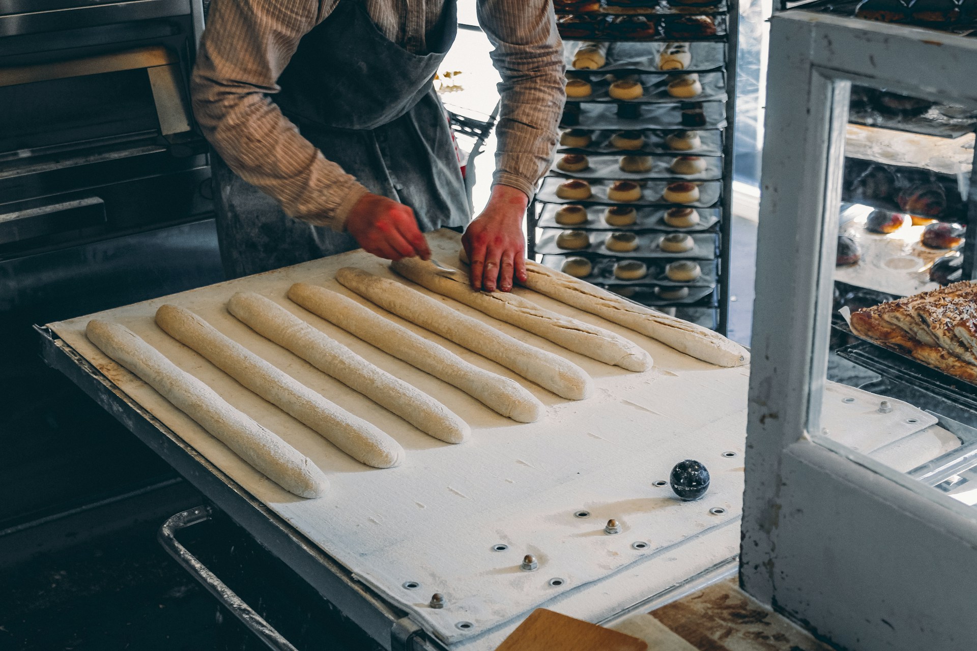 Fresh bread dough being shaped by hand at a bakery in Reykjavik, Iceland.