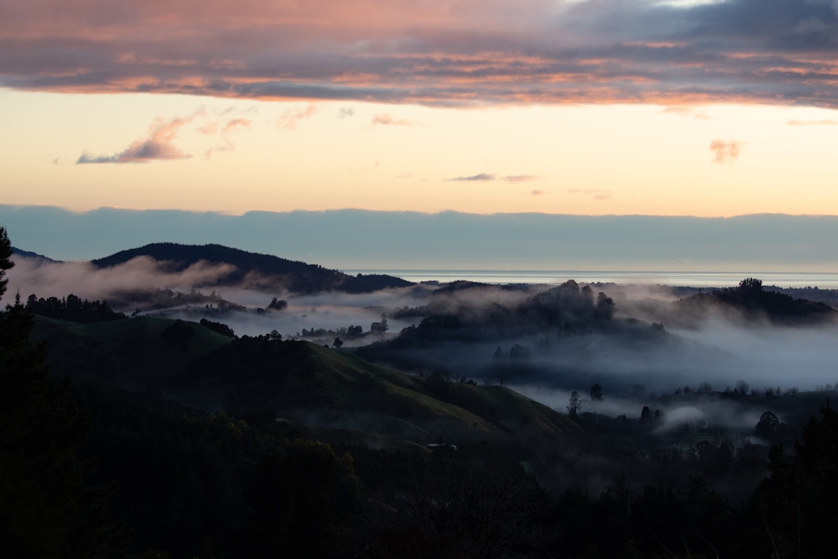 Foggy hills and distant ocean at sunrise