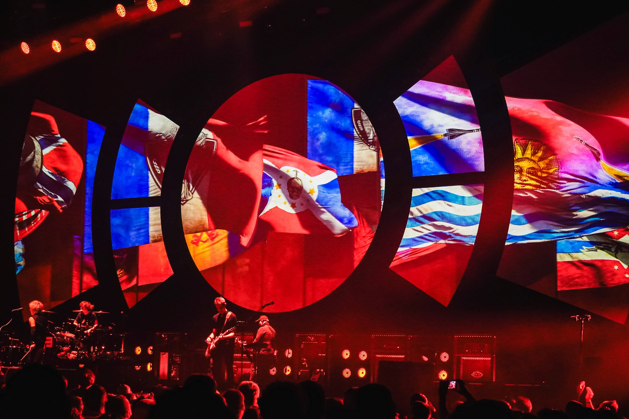 Écrans circulaires diffusant des drapeaux du monde, groupe sur scène en contrebas, Indochine