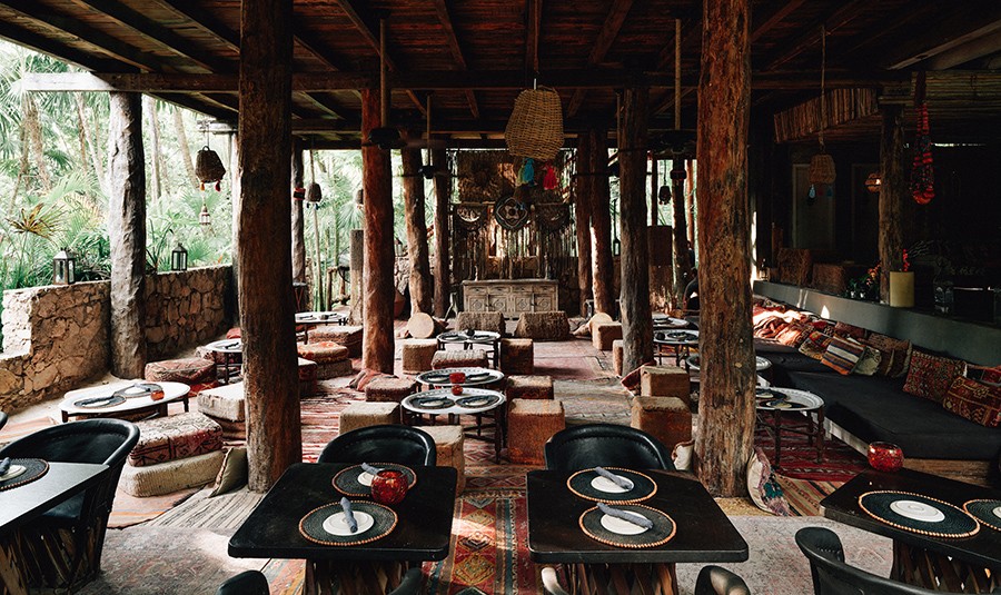 Group of people discussing their spiritual yoga journey on the beach at Nomade Holbox in Tulum Mexico, with a serene and peaceful atmosphere