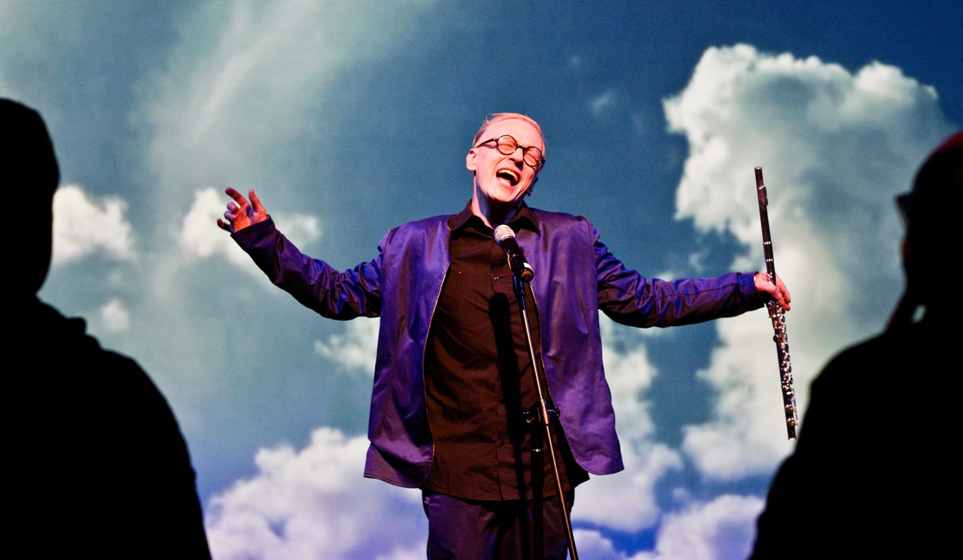 Man performing on Stage, singing in a microphone