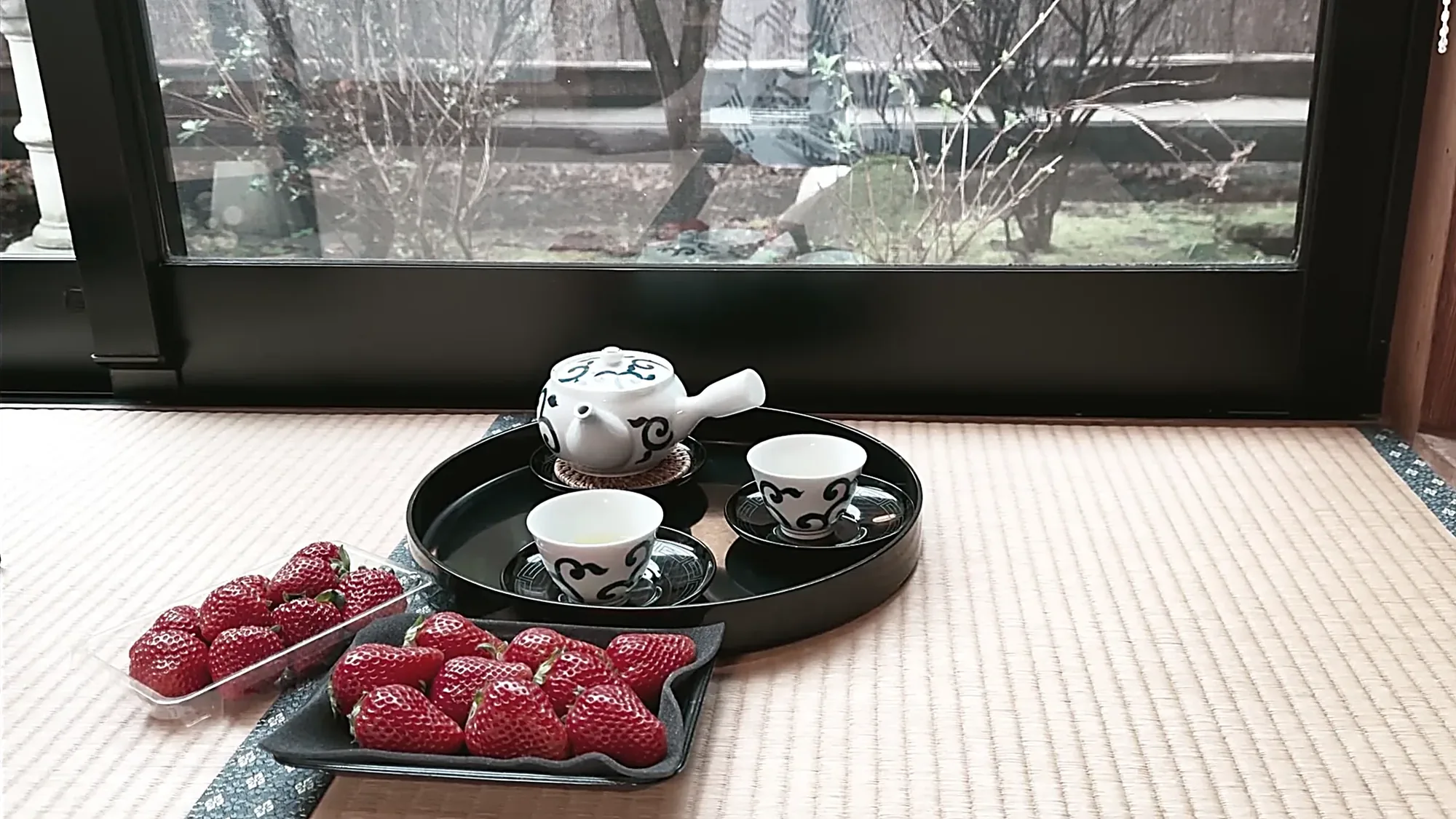A tea set and strawberries on a tray at the edge of a tatami room in Kurokawa Onsen