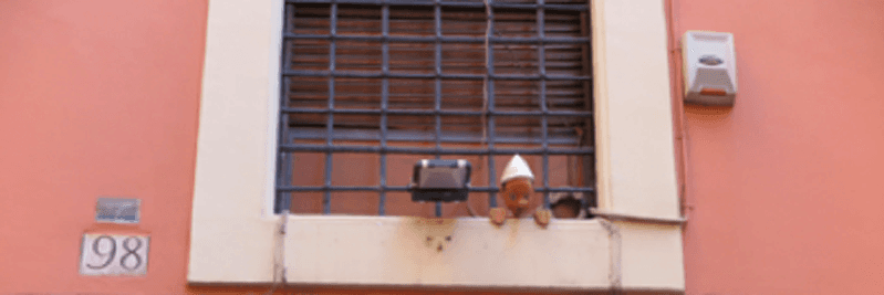photo of a window where is a small toy on the edge of the window frame