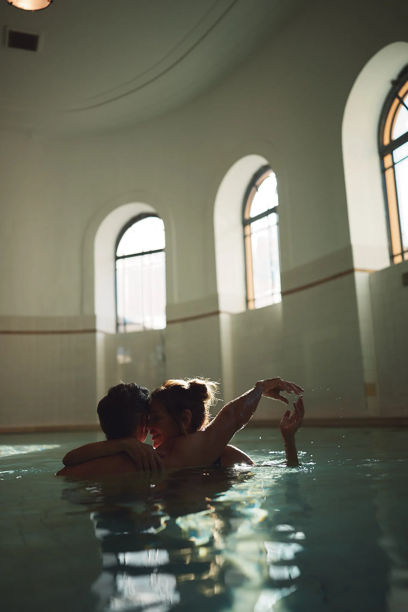 couple embracing in bathhouse pool — lifestyle photography by Tom Kubik