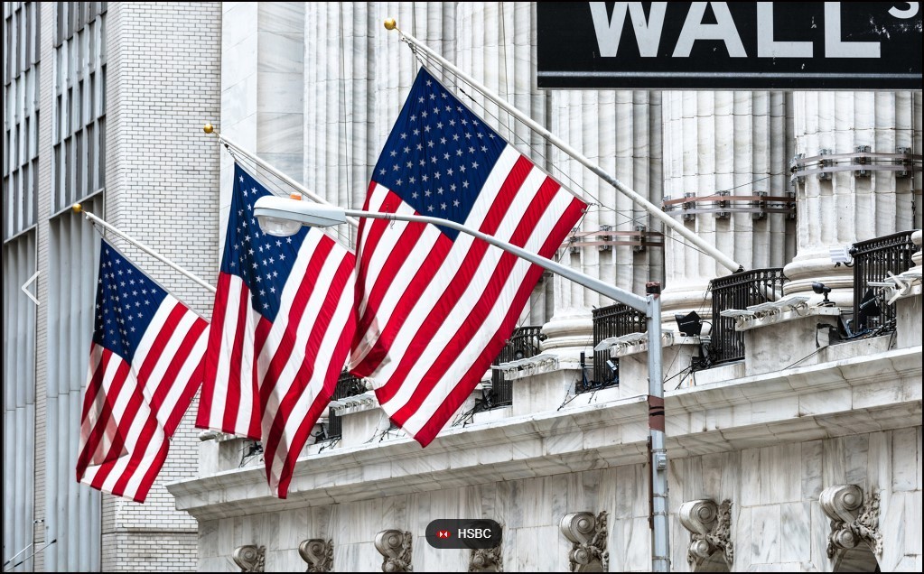 three US flags hanging on Wall Street.