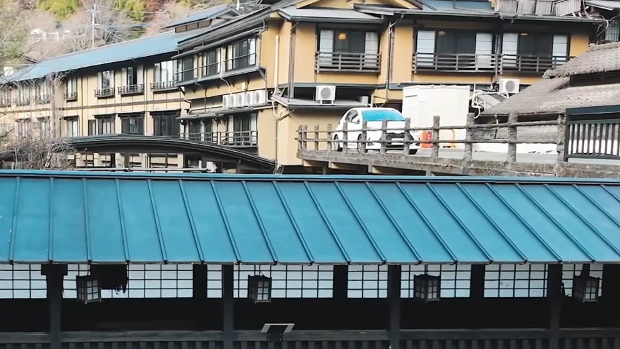The blue-roofed riverside walkway below the inns at Kurokawa Onsen