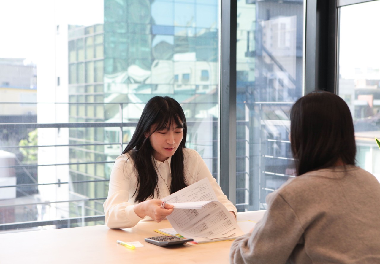 상담 테이블에서 서류를 보며 설명하는 세무사