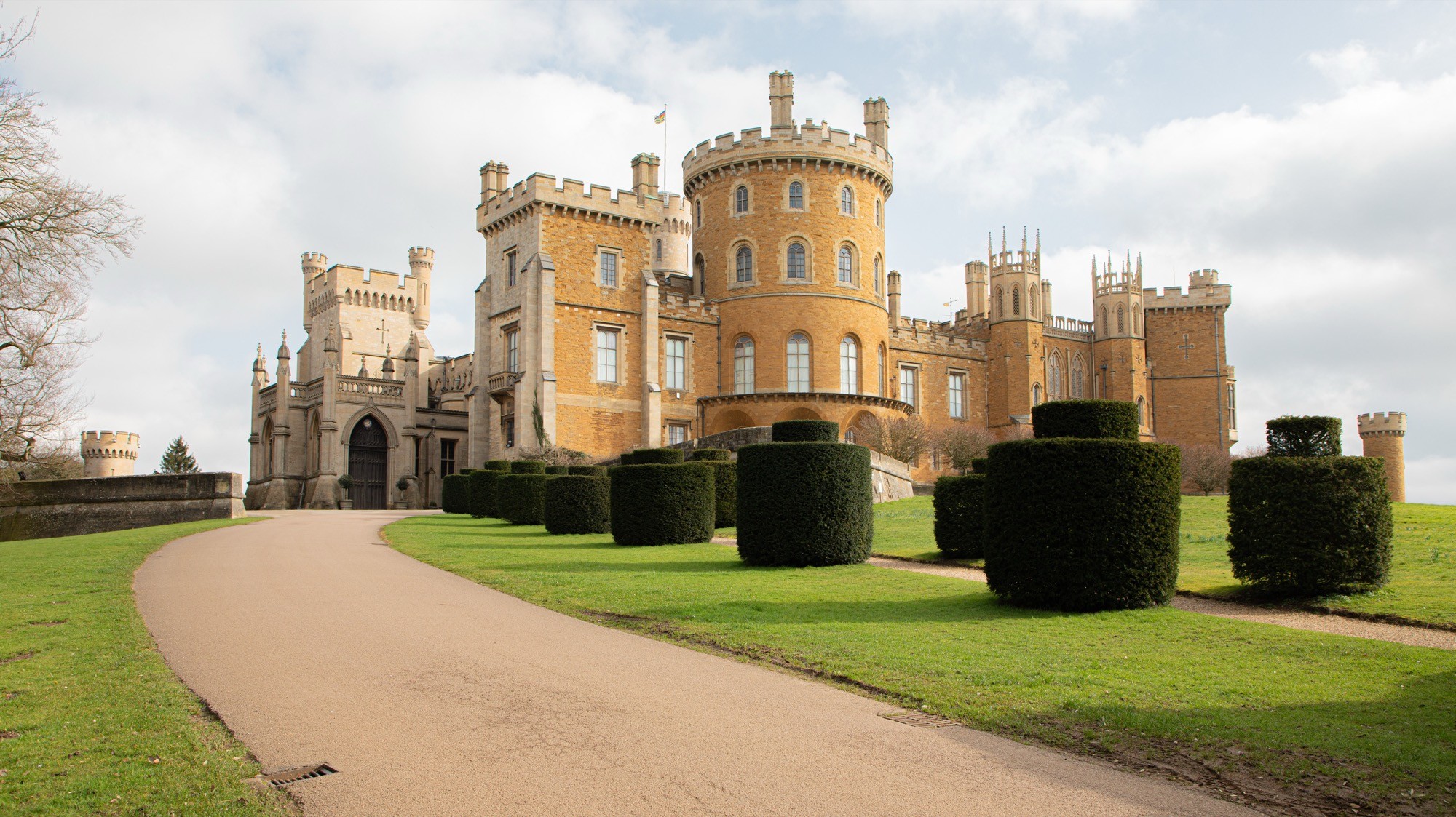 Two classic volkswagen beetles, one green, one cream.