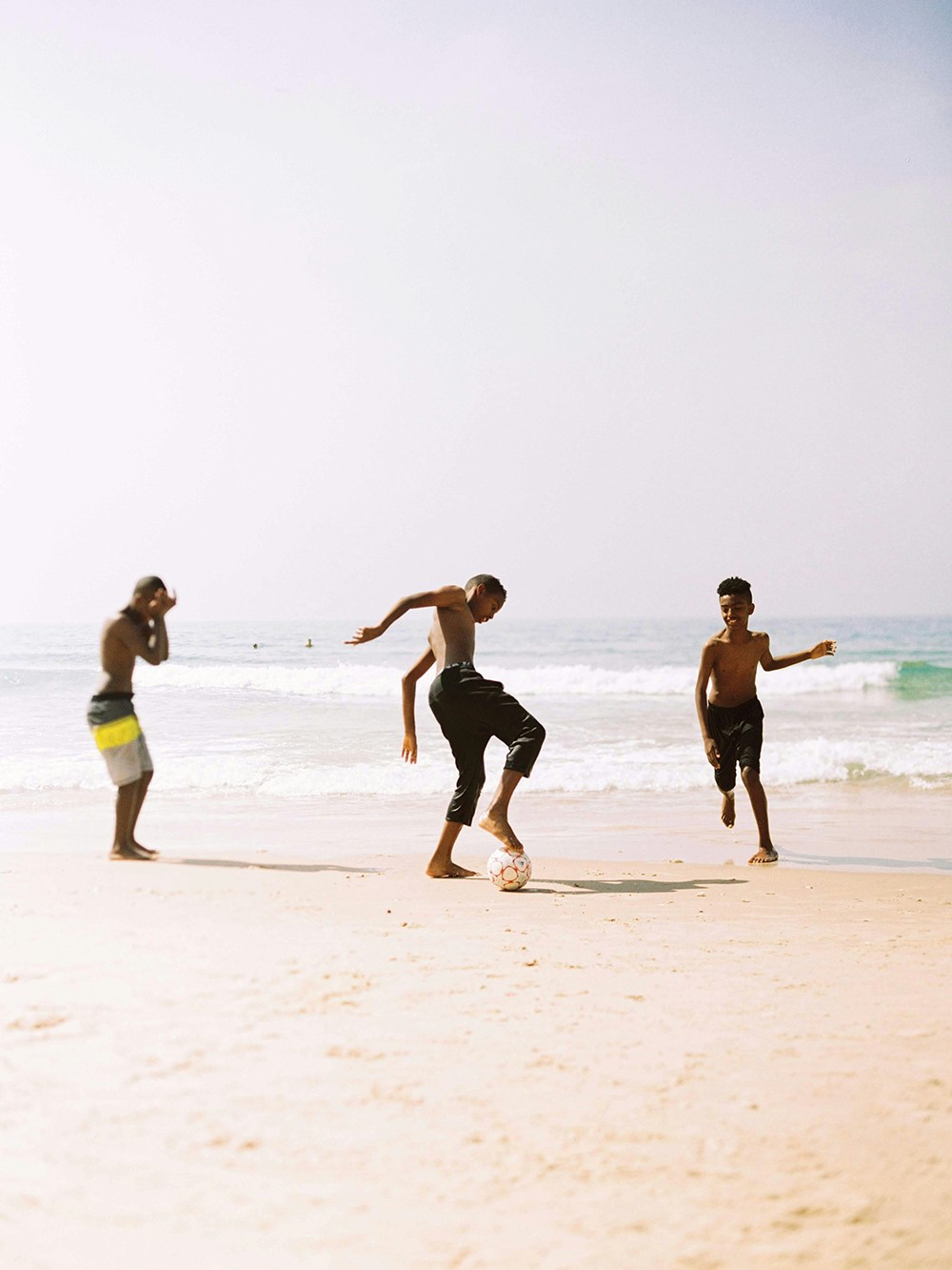 Kids playing football at the beach in brazil