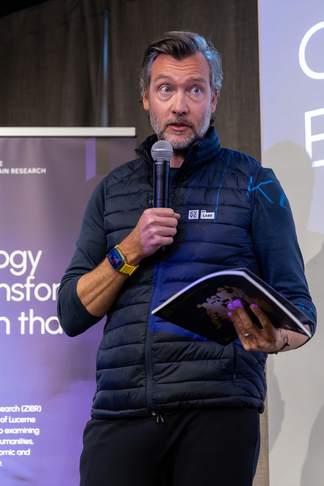 Conference moderator speaking during a live presentation.