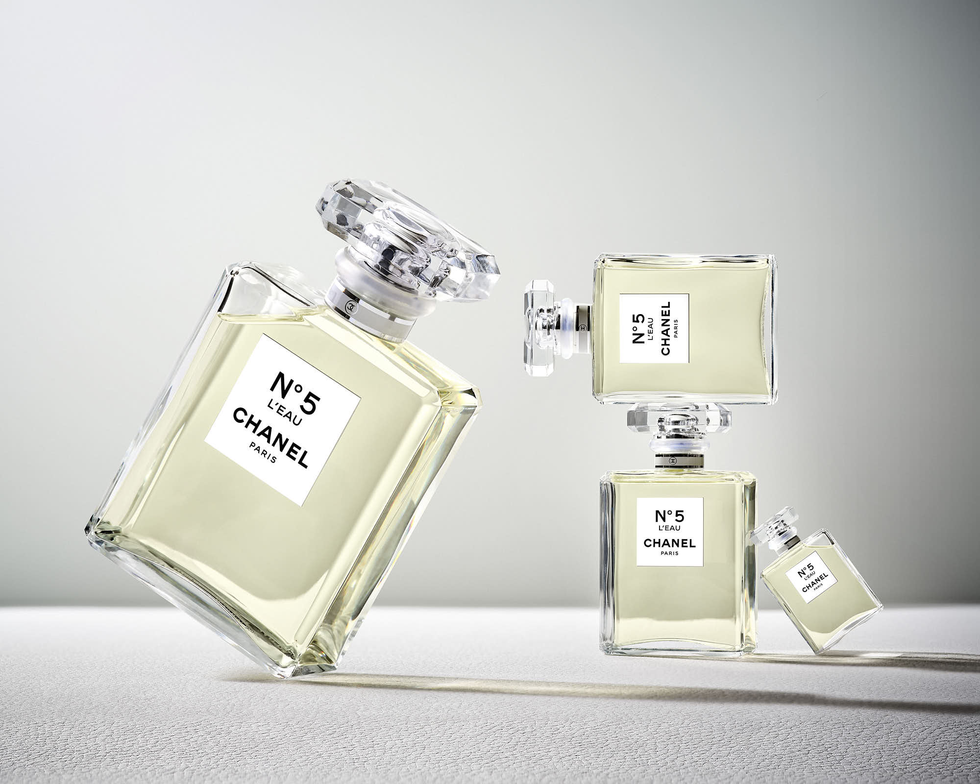 A stylish arrangement of a central bottle surrounded by several smaller bottles, casting dramatic shadows.