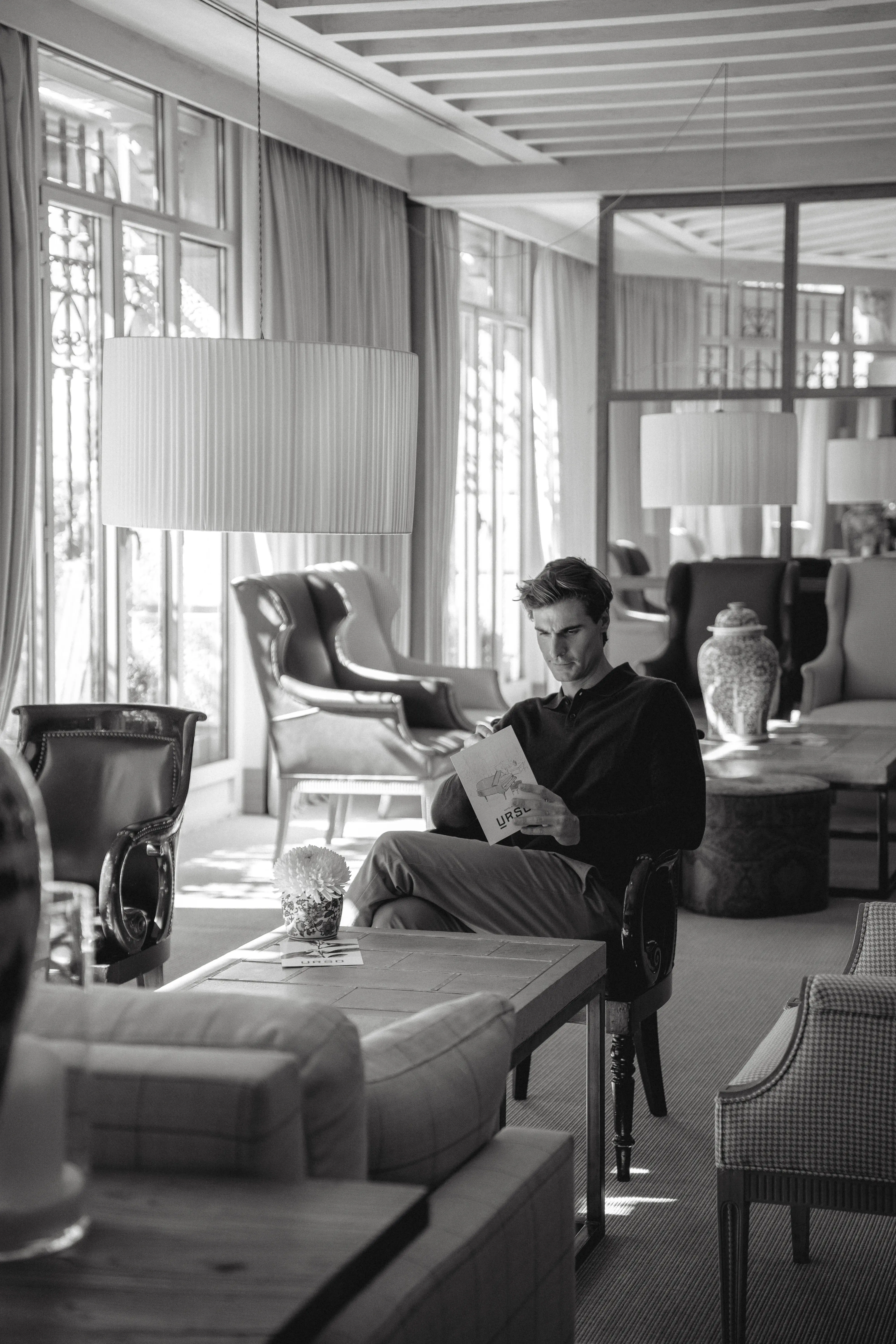 Homnbre joven leyendo revista en lobby hotel