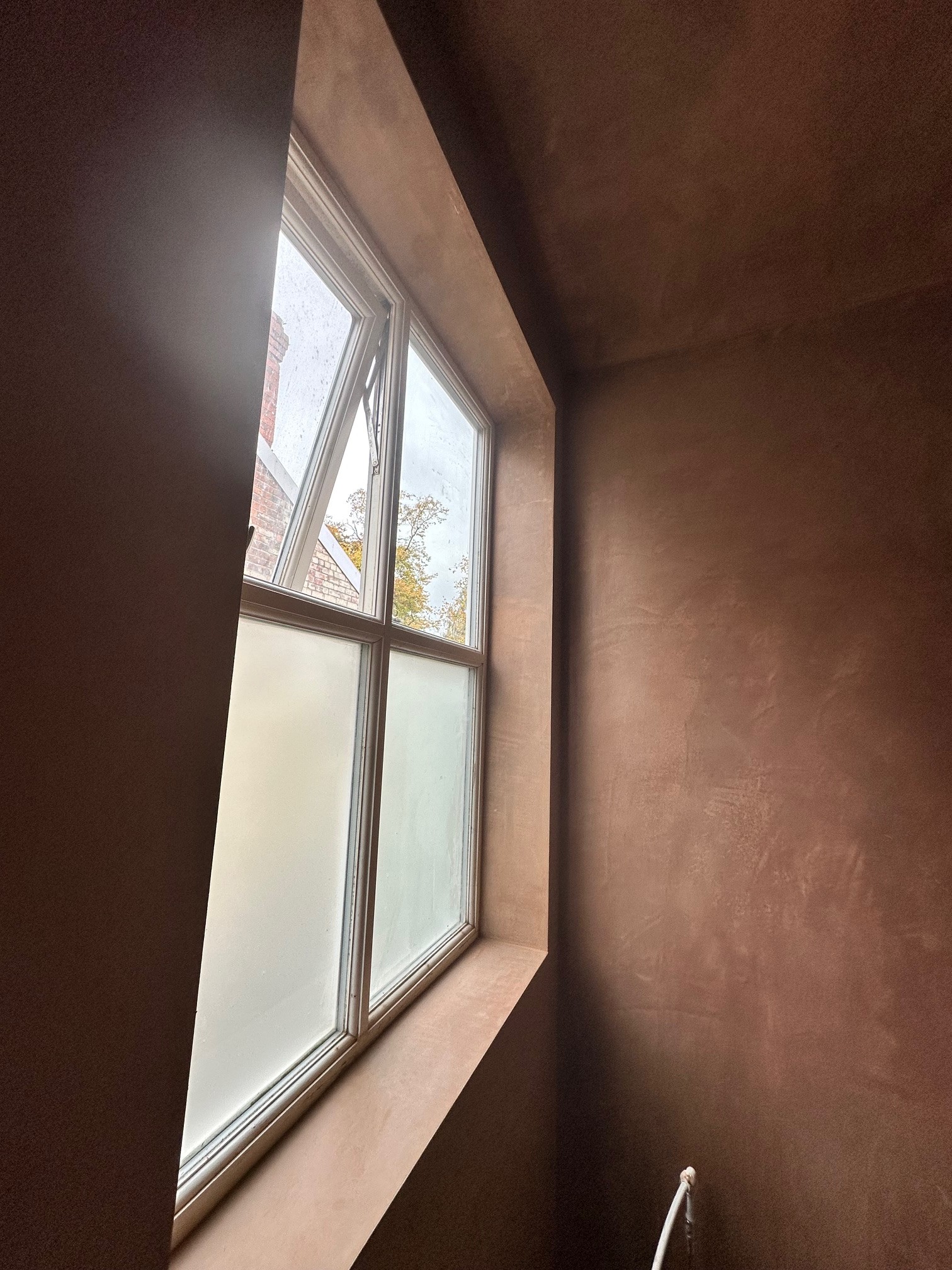 Bathroom window with freshly plastered window reveals.
