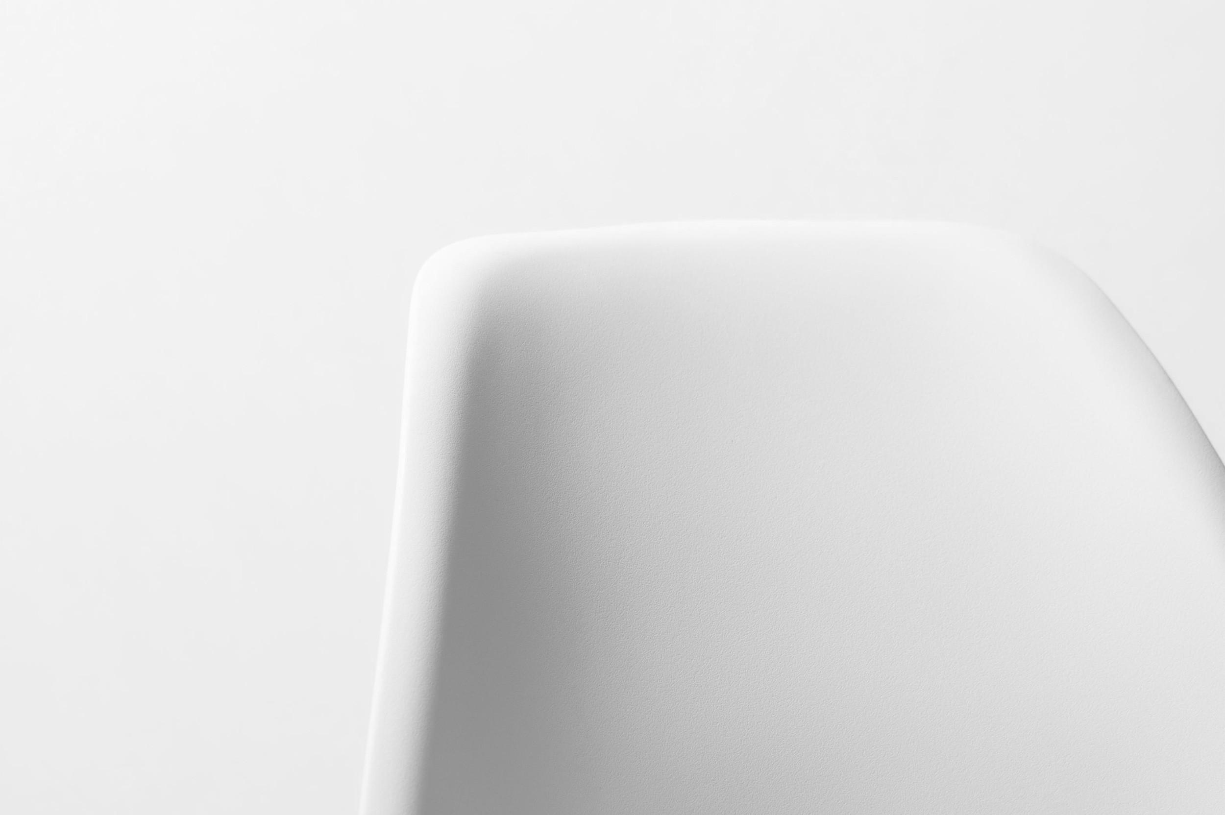 A minimalist black and white photo of a chair’s backrest with soft, rounded edges.