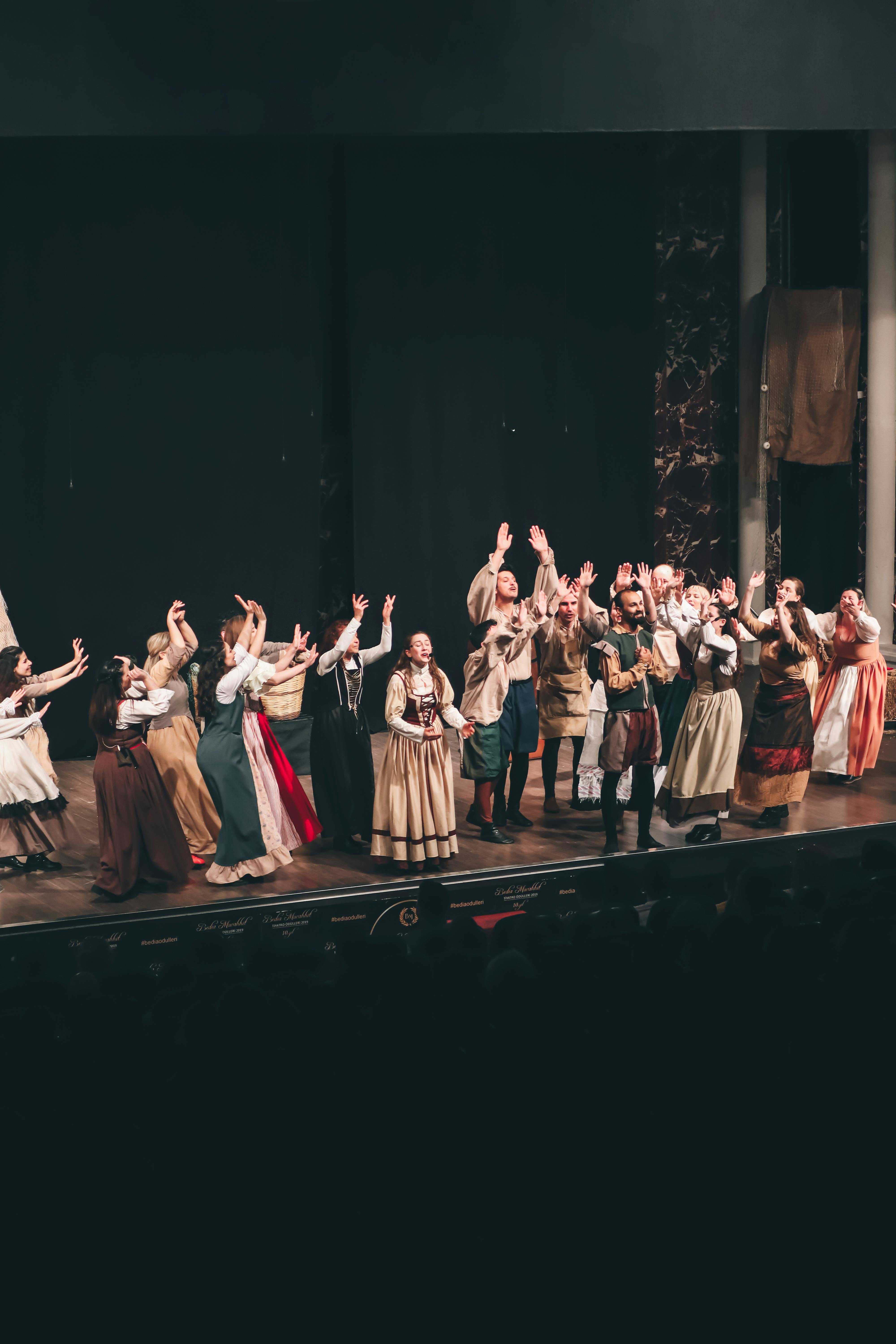 Un groupe de theatre sur scene salue le public