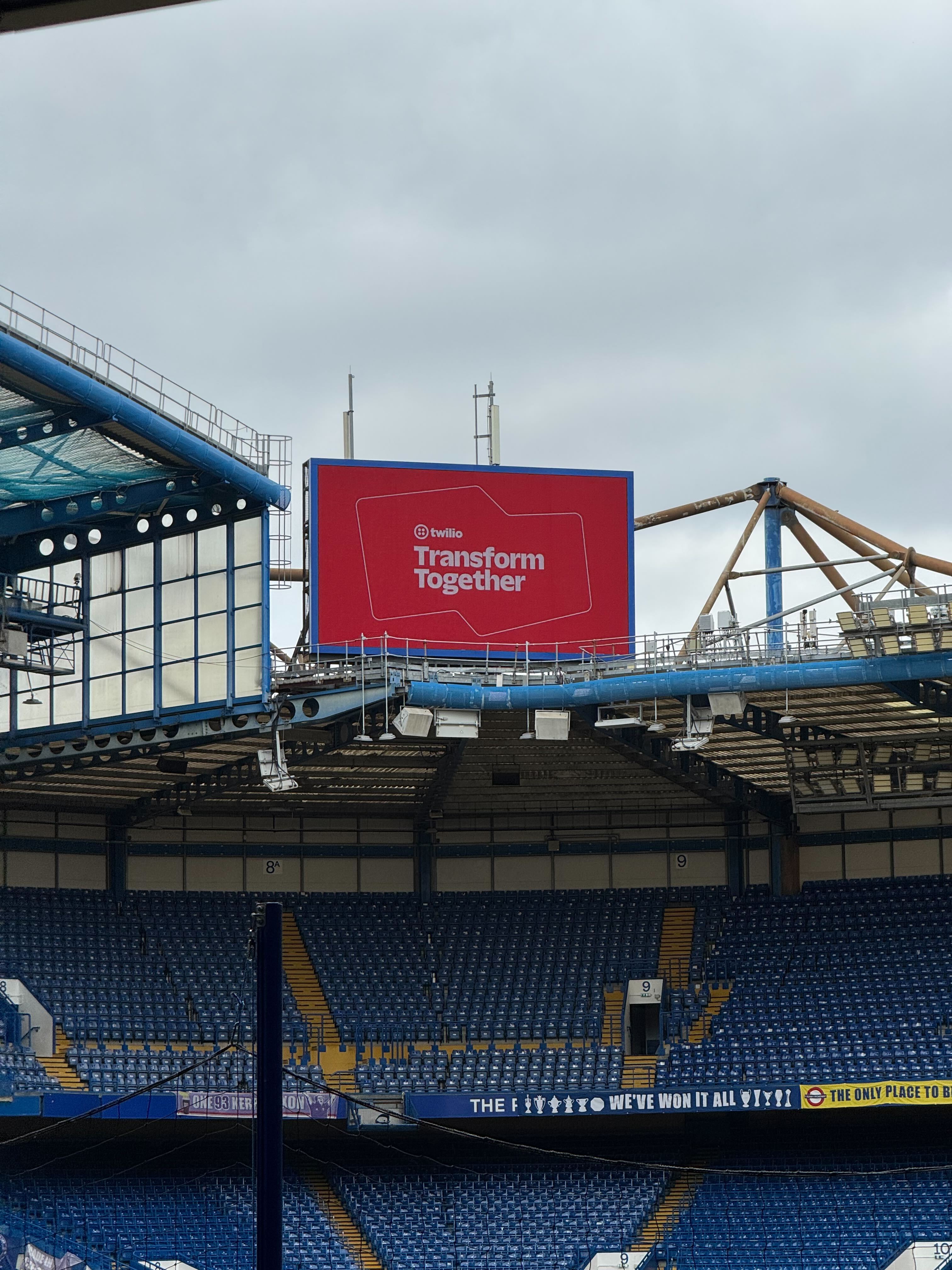 an image showing a screen in a football stadium, saying "twilio transform together"