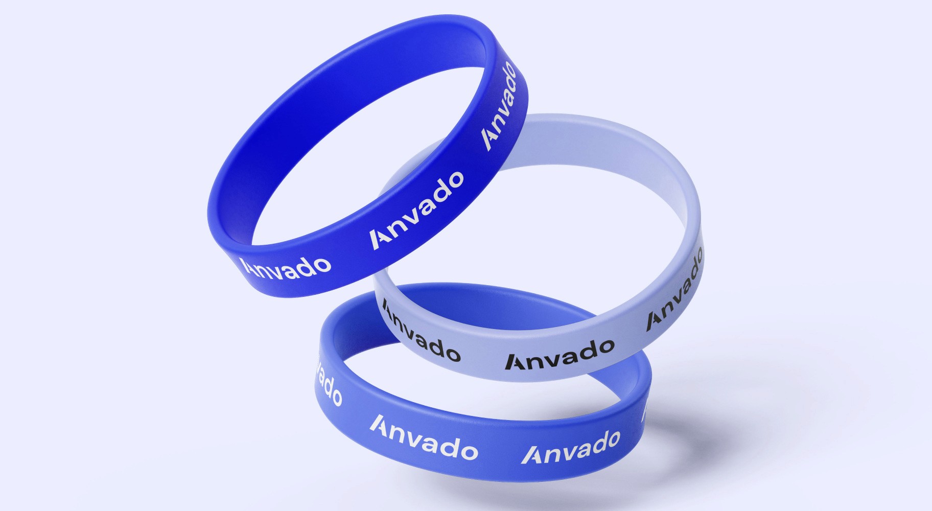 Three stacked rubber wristbands in shades of blue, each featuring the 'Anvado' logo in white text, floating against a light blue background.