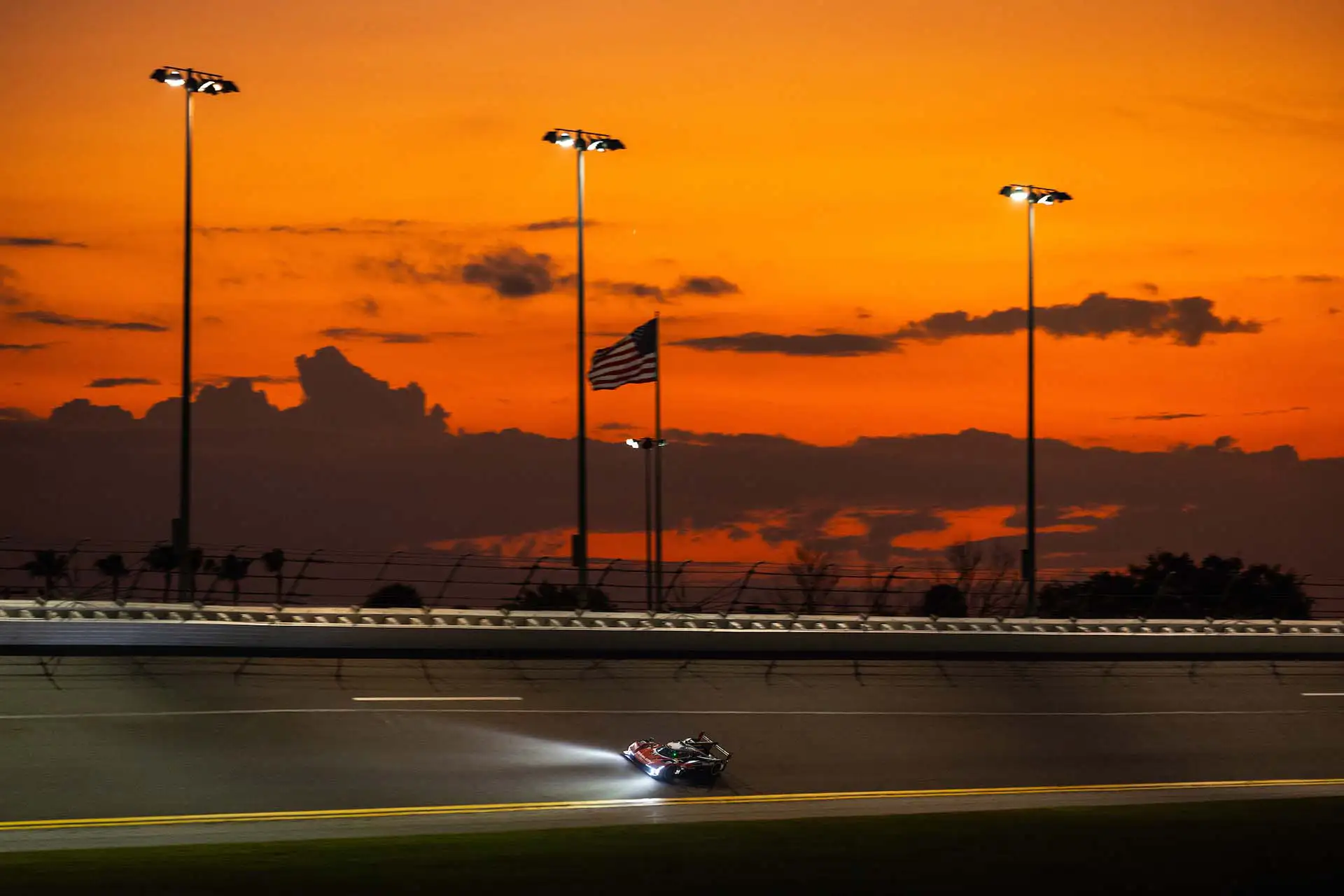 A racecar driving on track at dusk.