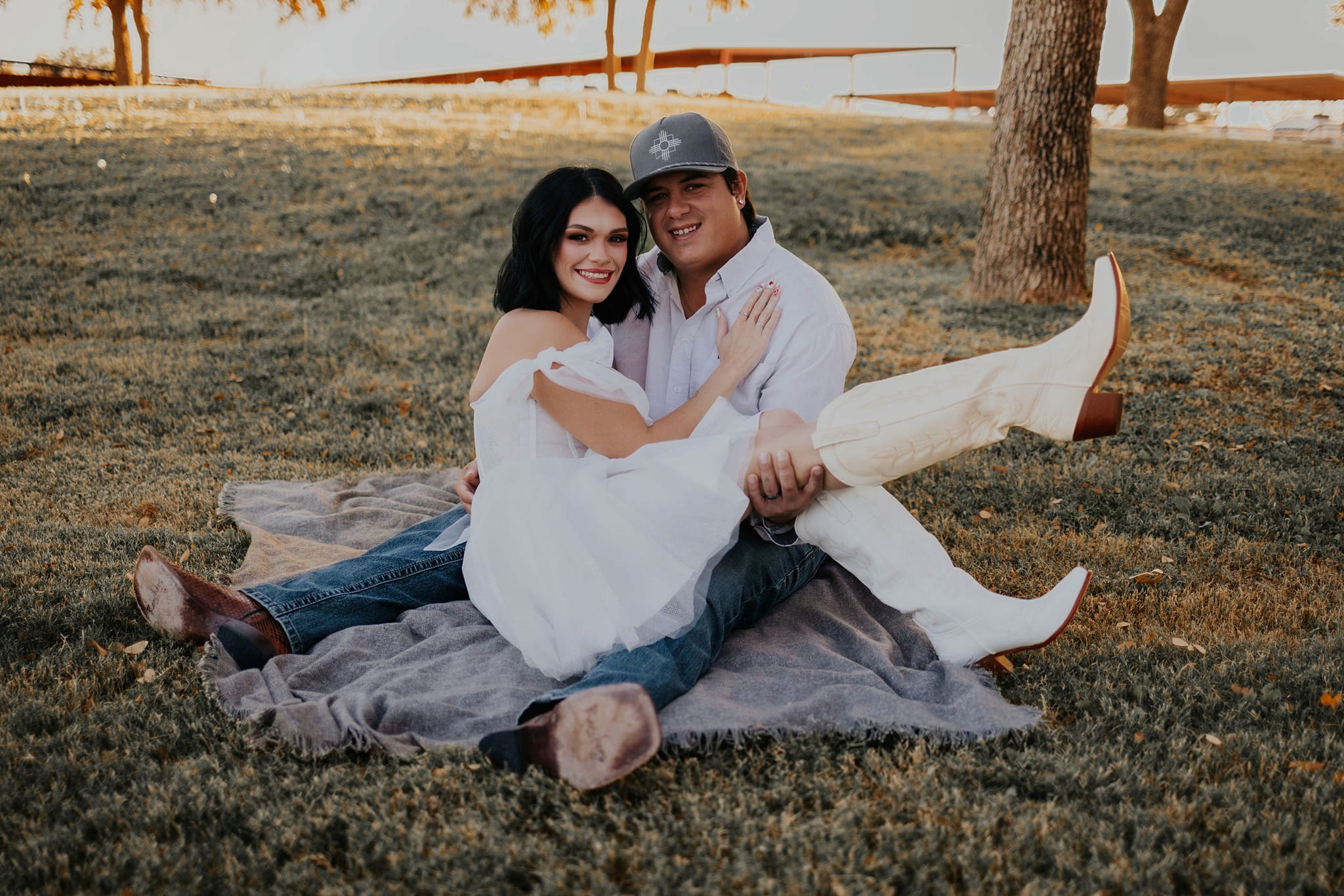 A couple smiling for a photo in a park.