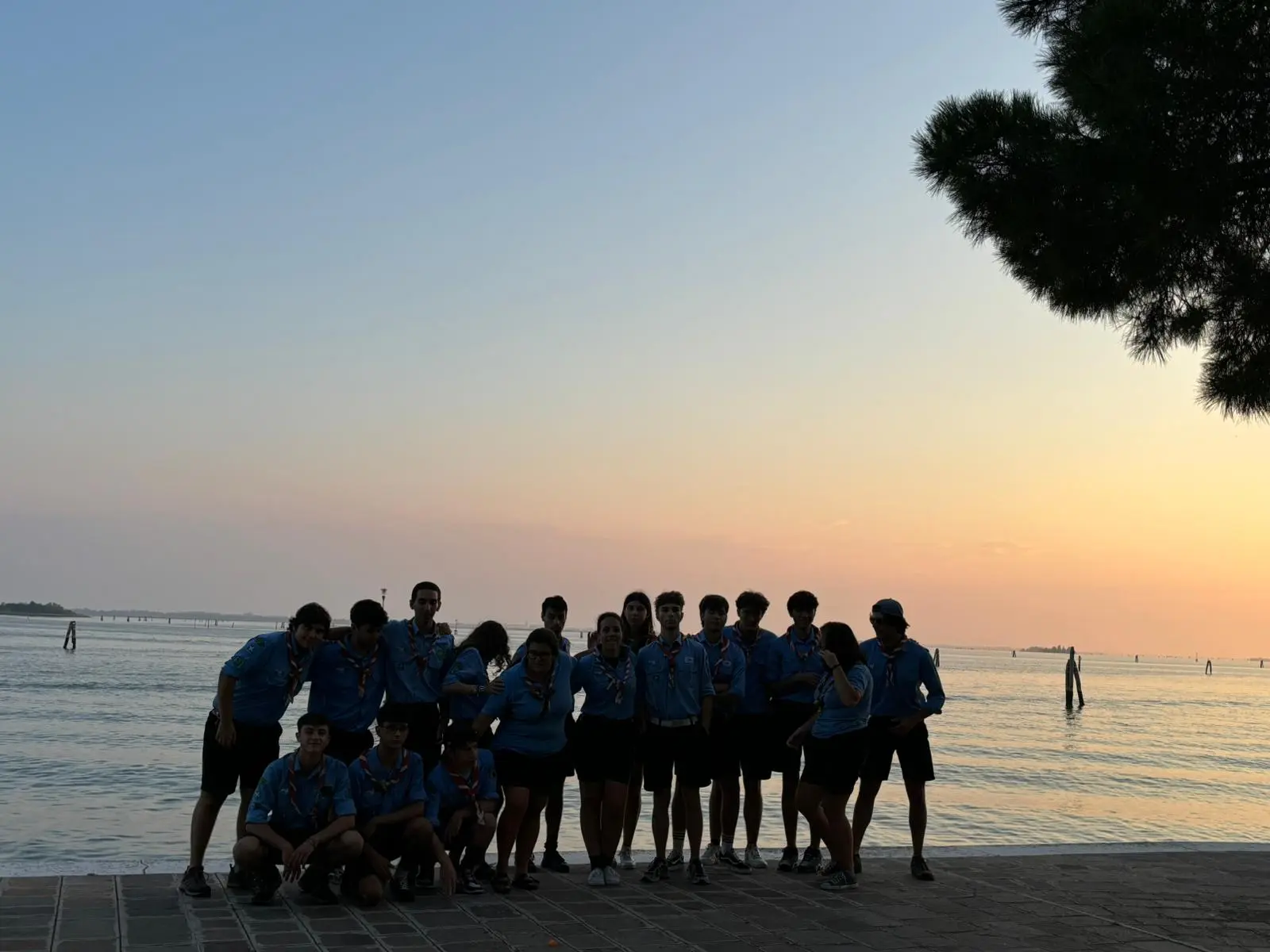 Scout in riva al lago al tramonto