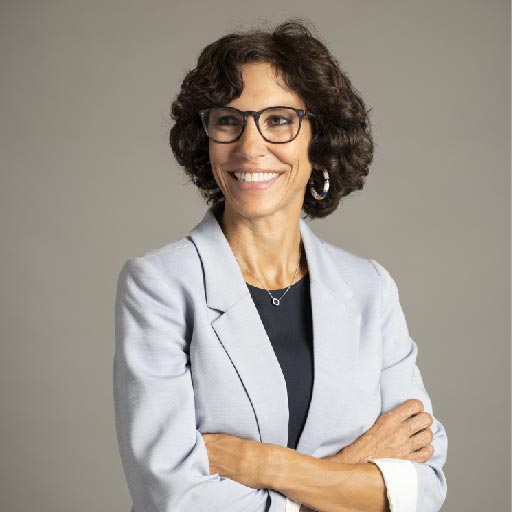 Portrait of a laughing person with curly hair wearing a white shirt