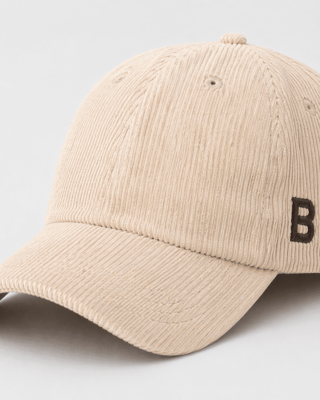 Beige corduroy cap with a brown 'B' logo on a light gray background