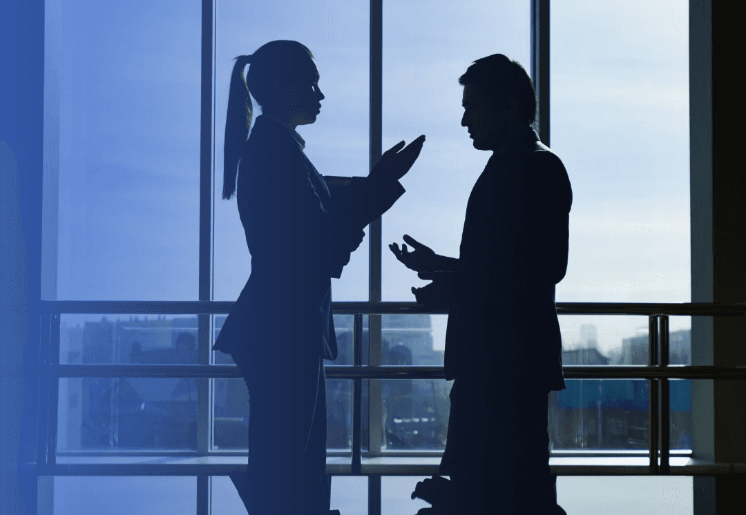 A silhouette of two bank employees discussing ideas