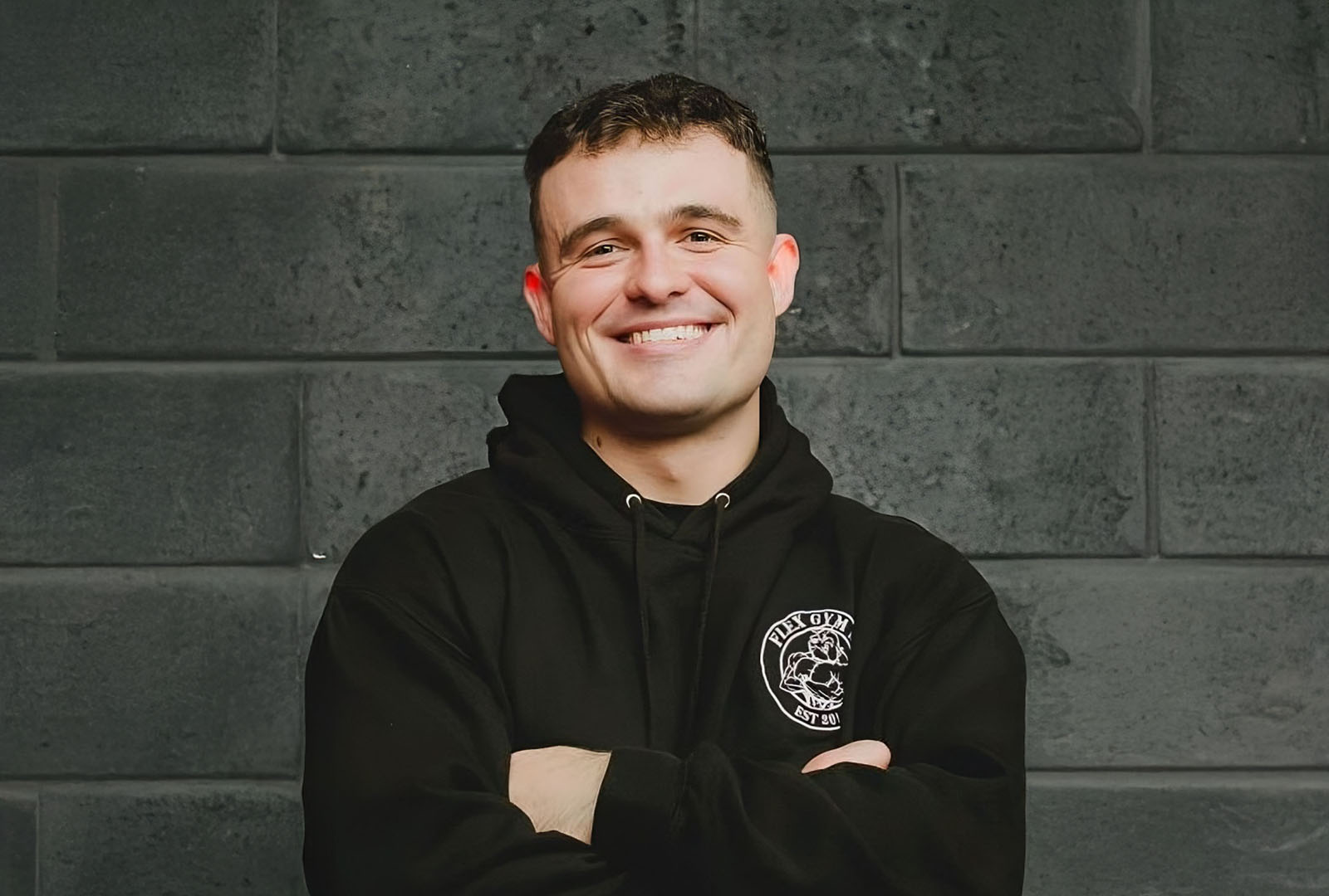 Close-up of lush, dark green leaves, some glossy and wet, against a muted background.