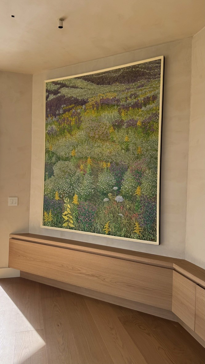 Large abstract wildflower meadow painting installed above a built-in wood console