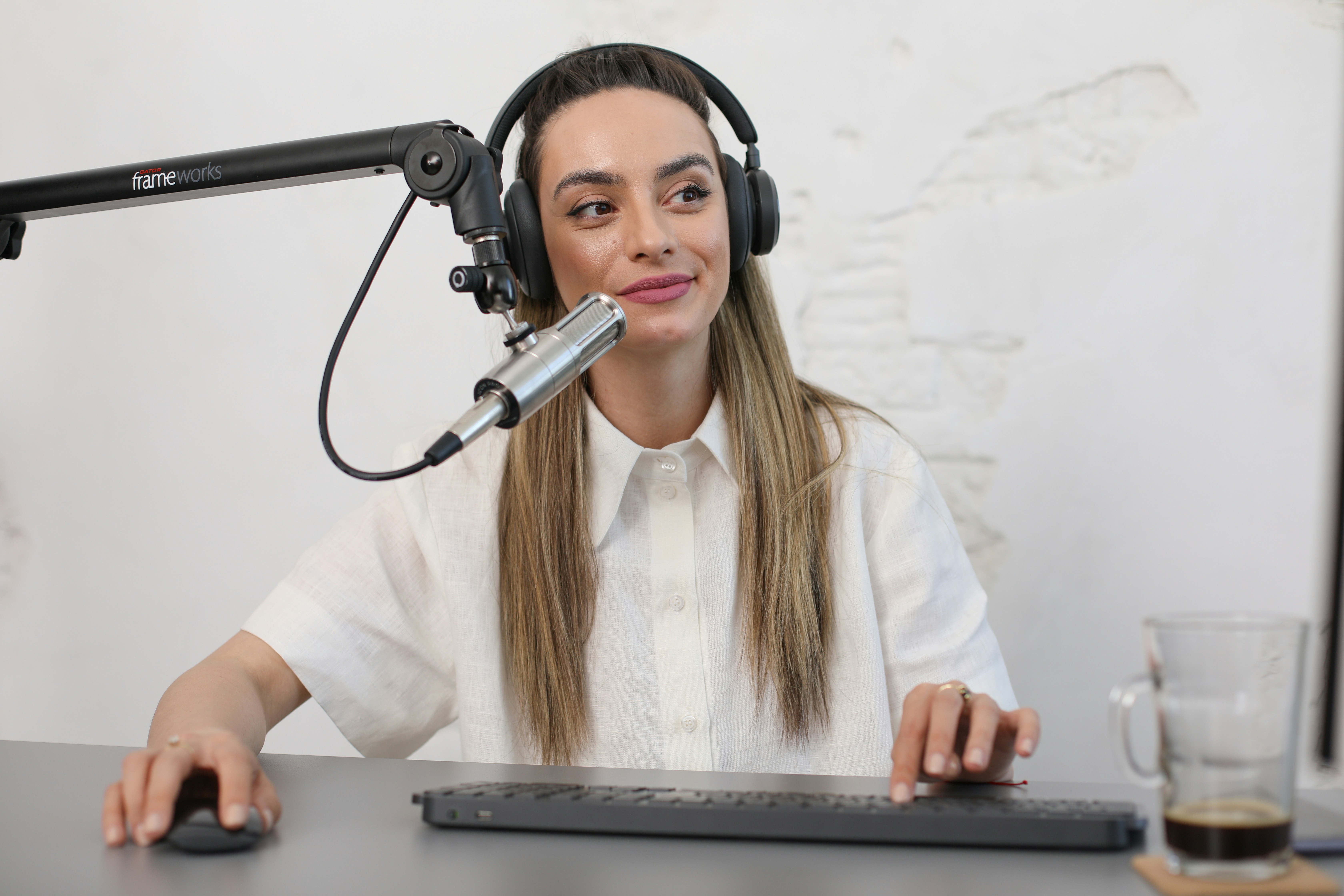 happy woman using mic and computer to record music