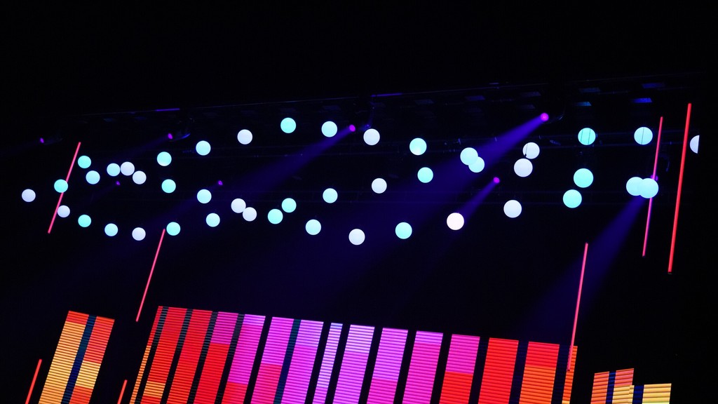 Creative event lighting design with suspended illuminated spheres, purple beams and red lighting effects