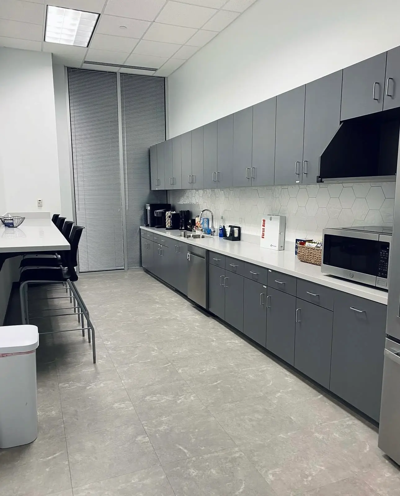 Sanitized commercial office breakroom with grey cabinetry and clean countertops after a professional business cleaning service.