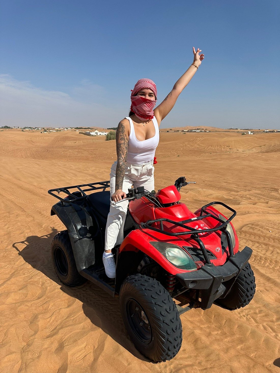 Charlotte Blackwell posing on a red quad bike during her Dune Quest Tours experience, rated the best luxury Desert Safari 2026