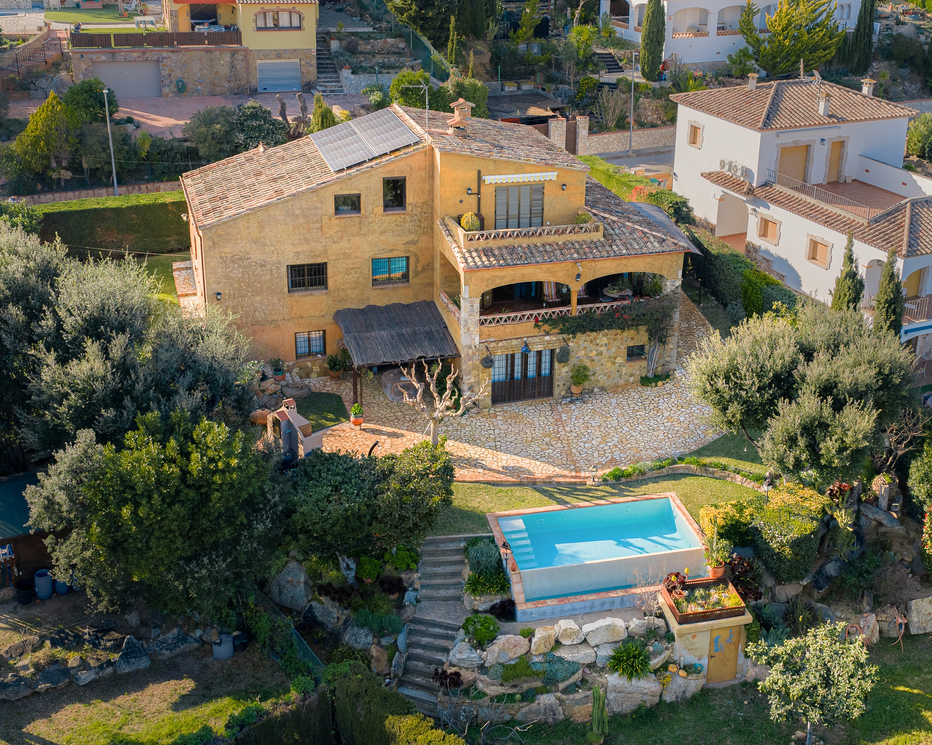 Primer plano de una terraza cubierta con mesa de comedor y vistas panorámicas a las montañas y al valle, fotografía inmobiliaria profesional en Costa Brava.