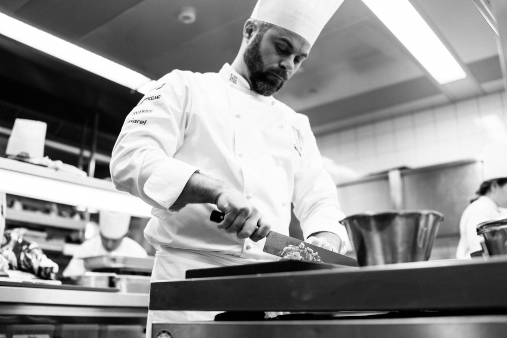 Overhead view of five colorful cocktails held above a table covered with records, magazines, and books. Photo: Iceland Hotel Collection by Berjaya