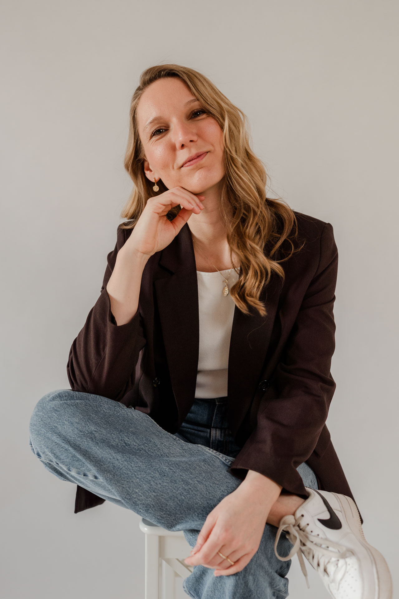 Sitzendes Portrait von OHNORD studio Gründerin Veronika aus Straubing. Sie sitzt auch einem Hocker in entspannter Pose und strahlt eine Ruhe aus, die eine Gründerin braucht. 