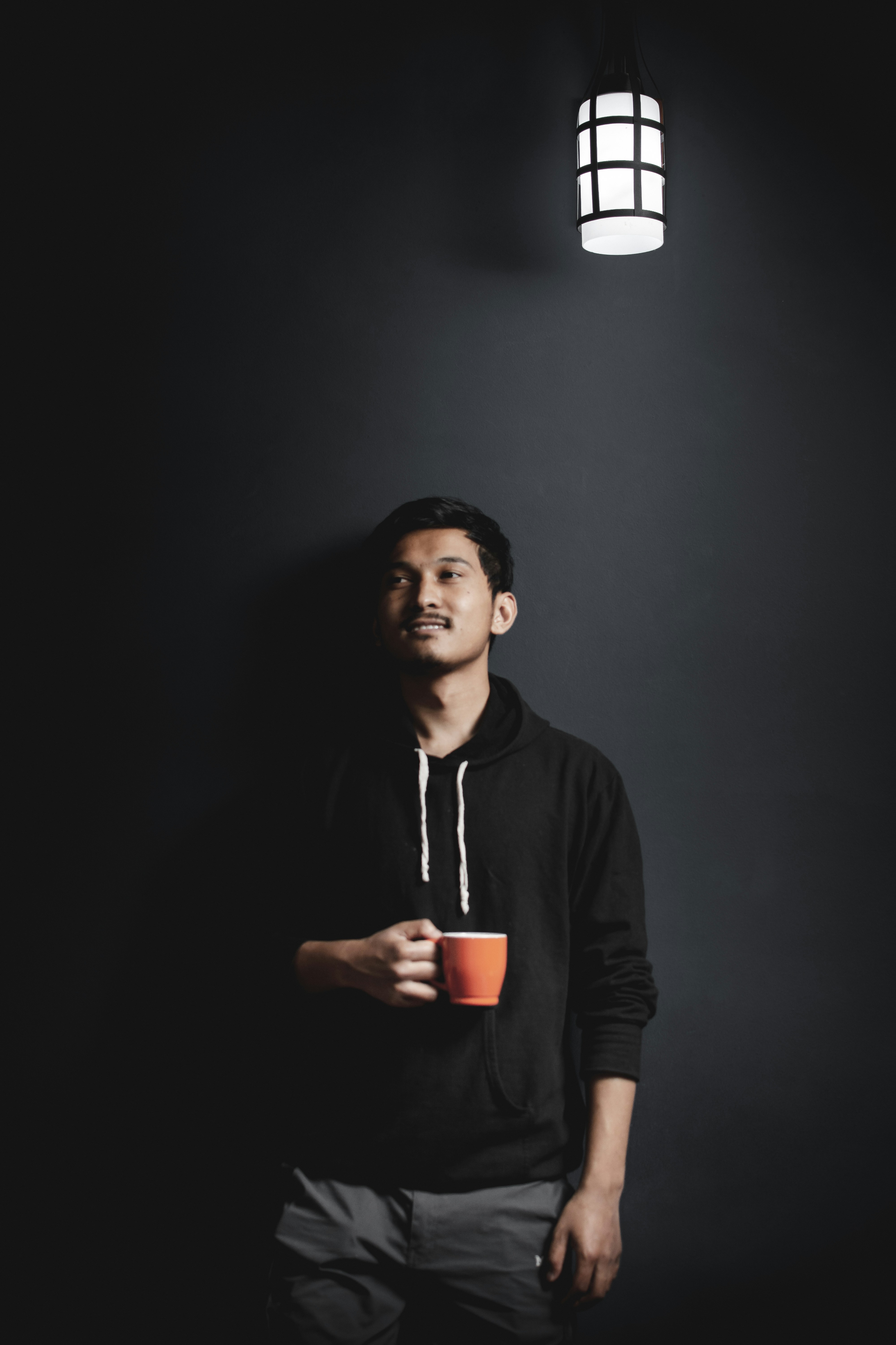 man in black hoodie holding red cup