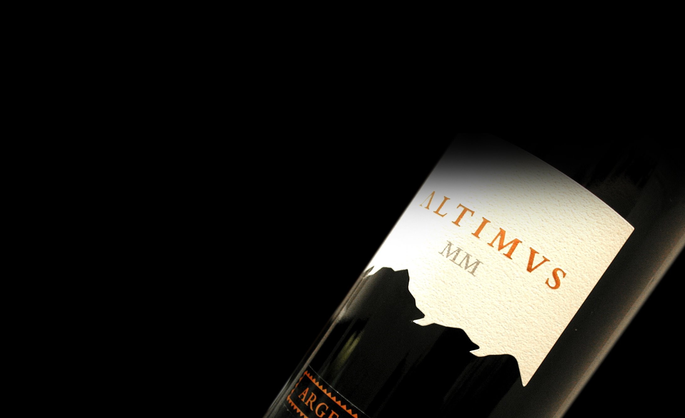 A bottle of wine angled against a black background. The label reads "ALTIMUS MM" with a silhouette of mountains, conveying elegance and sophistication.