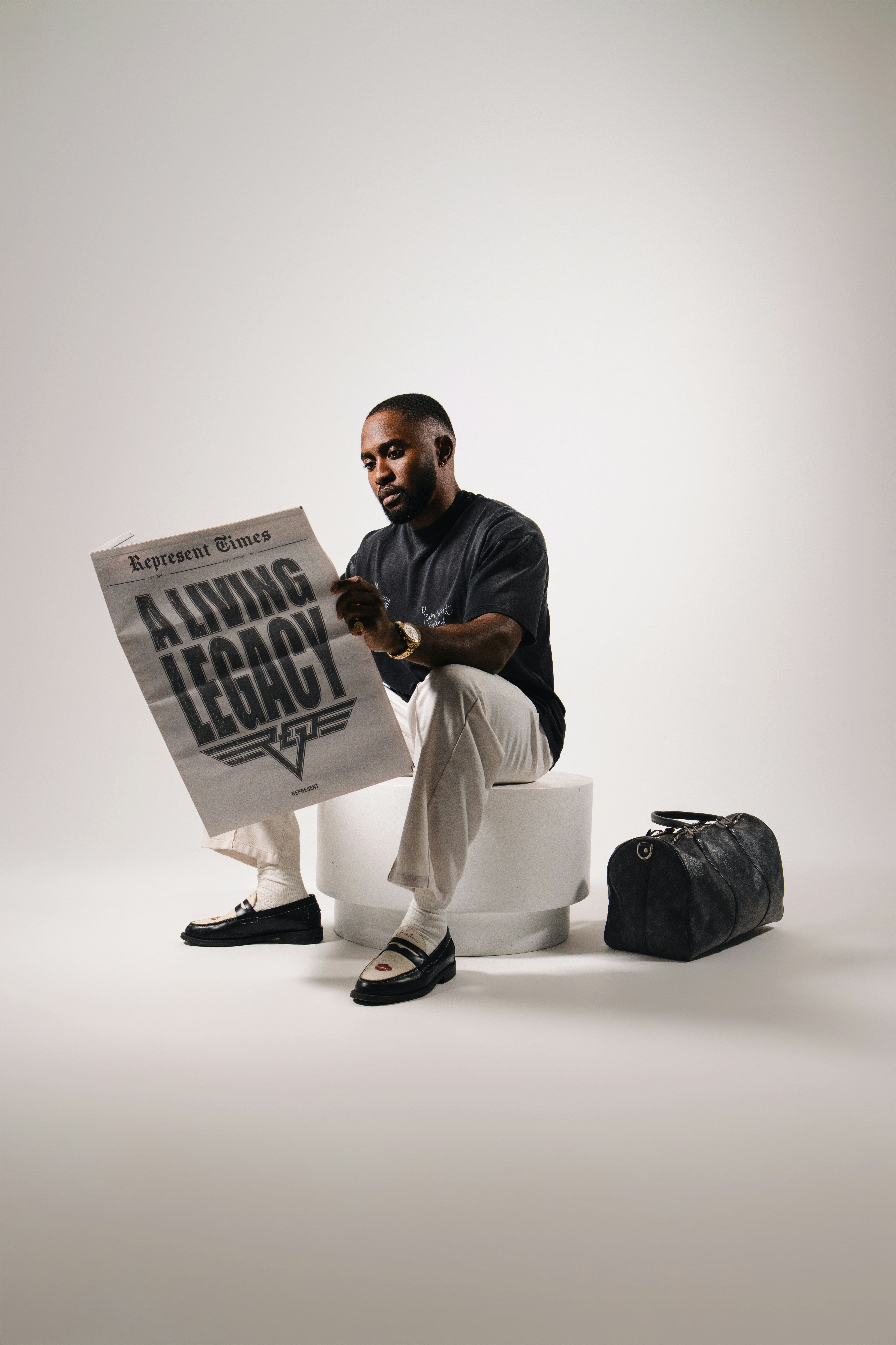 Man reading newspaper with "a living legacy" headline.