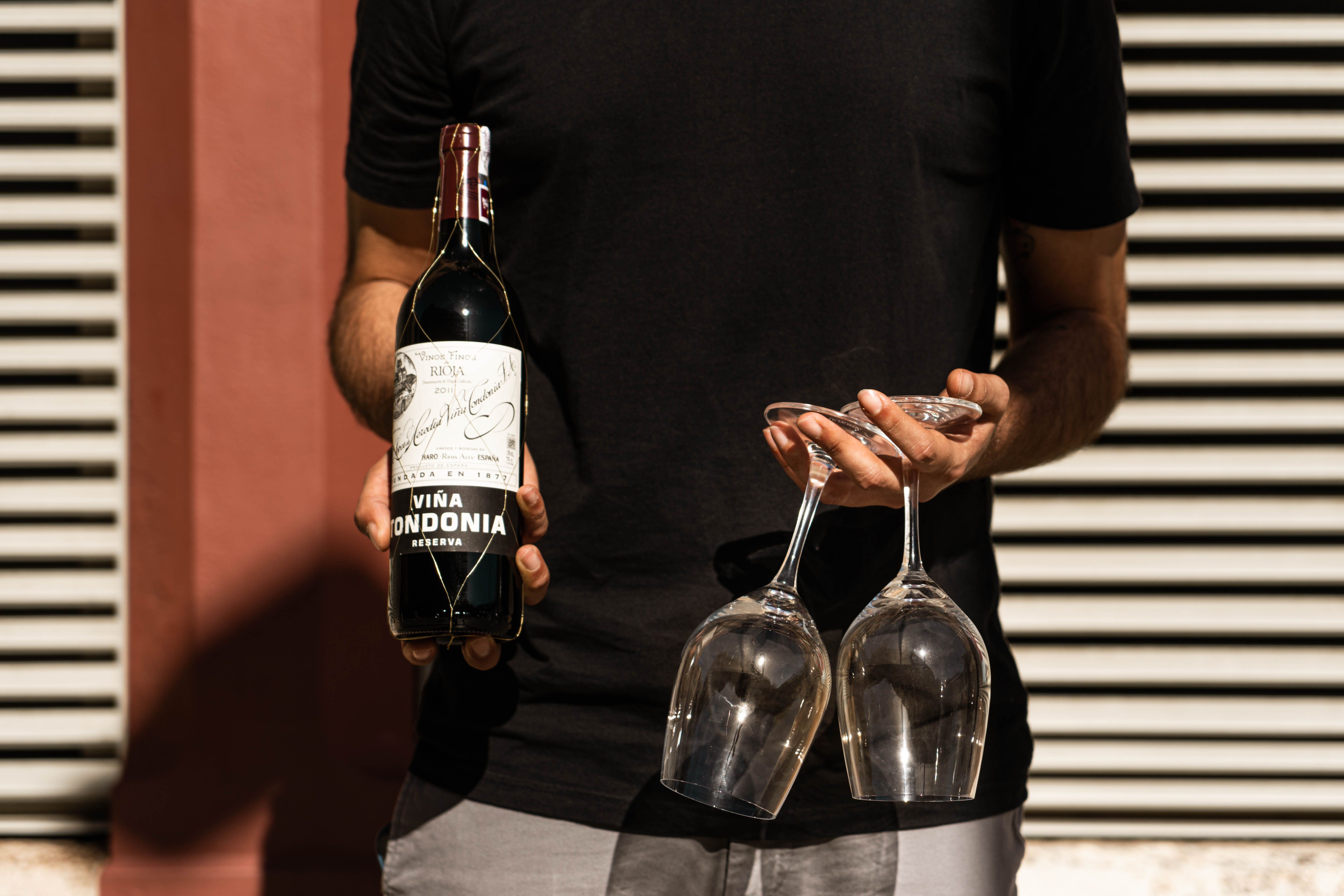 Sommelier holding a bottle of wine and glasses during a Barcelona food and wine experience.