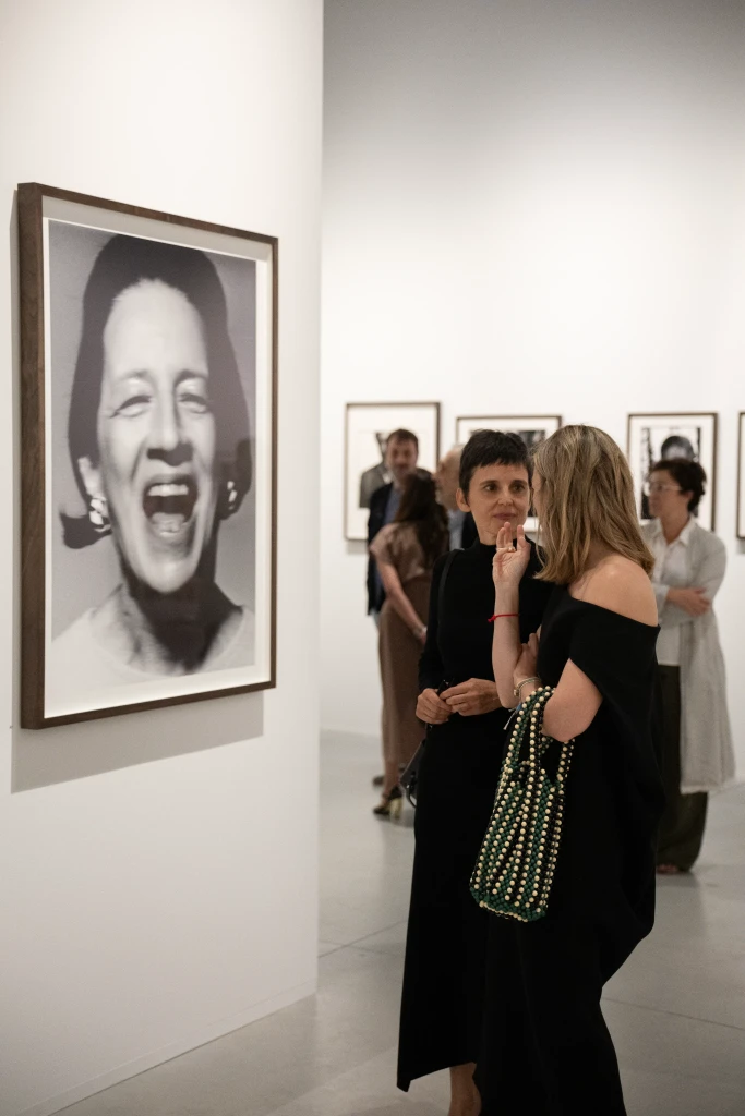 Mujer hablando con Marta Ortega viendo un cuadro de la exposicion