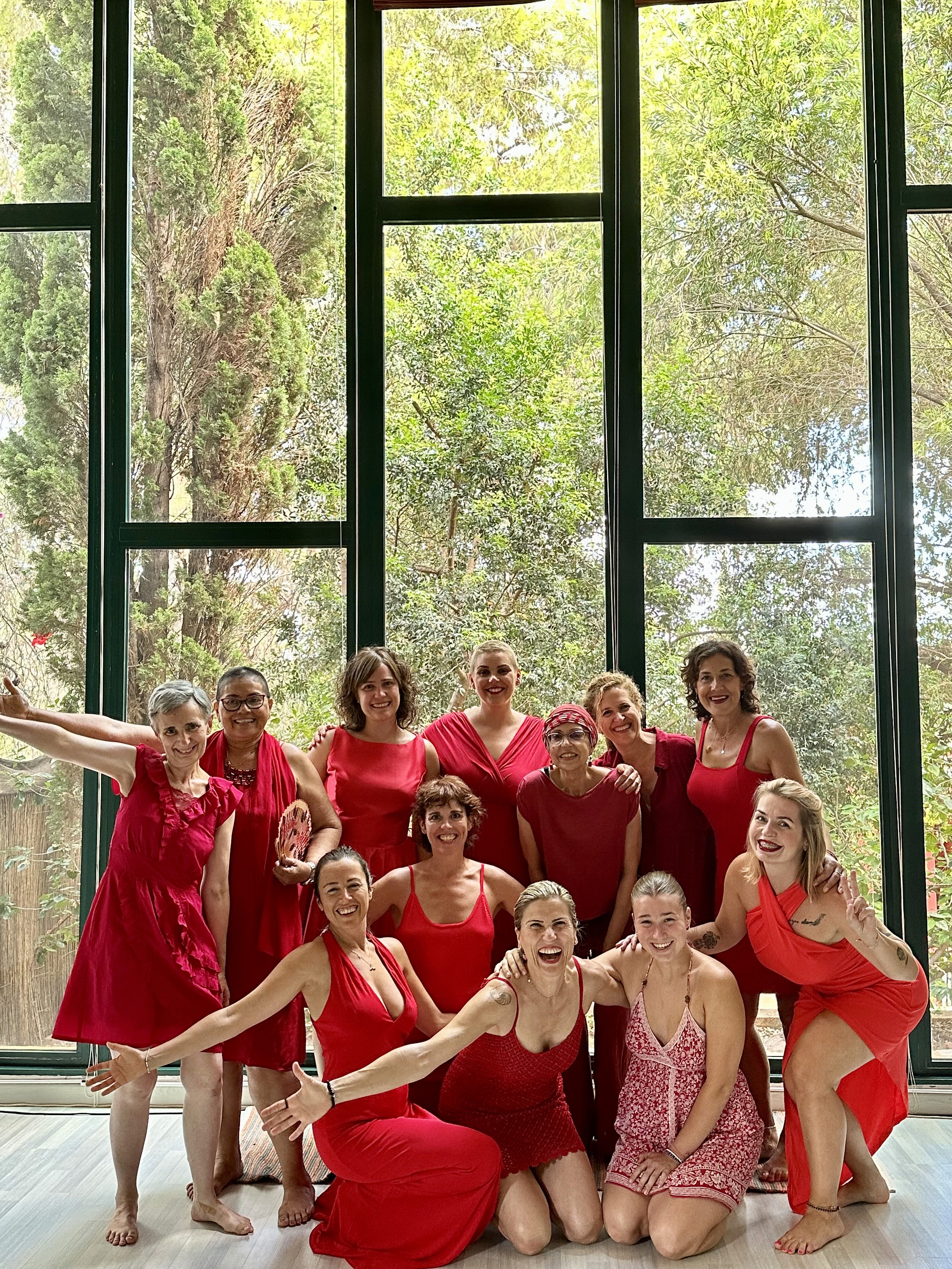 grupo de mujeres vestidas de rojo frente a ventanal de retiro
