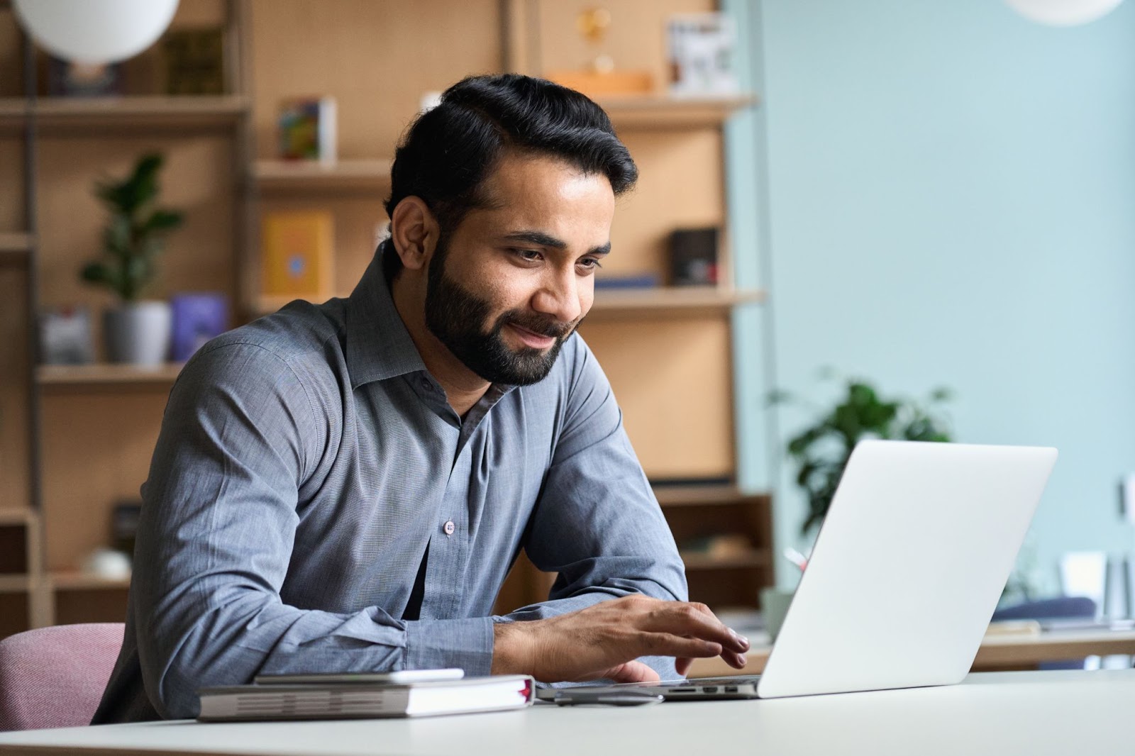 B2B marketing tools: Smiling man working on his laptop