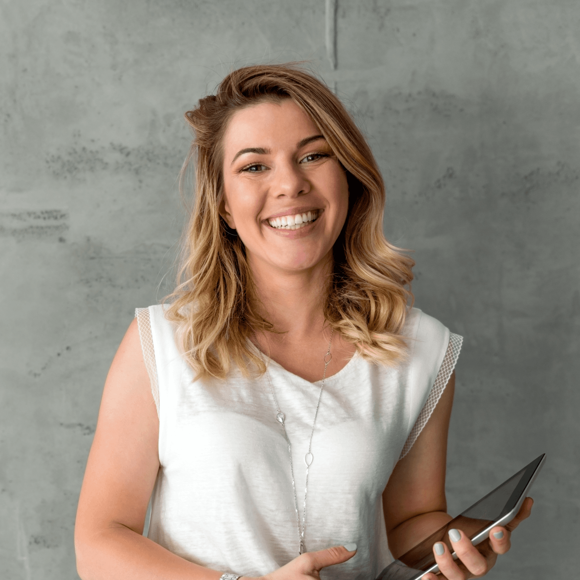Woman in a blue shirt poses confidently with folded arms, wearing glasses and jewelry. Neon lighting casts a purple and pink glow, creating a vibrant mood.