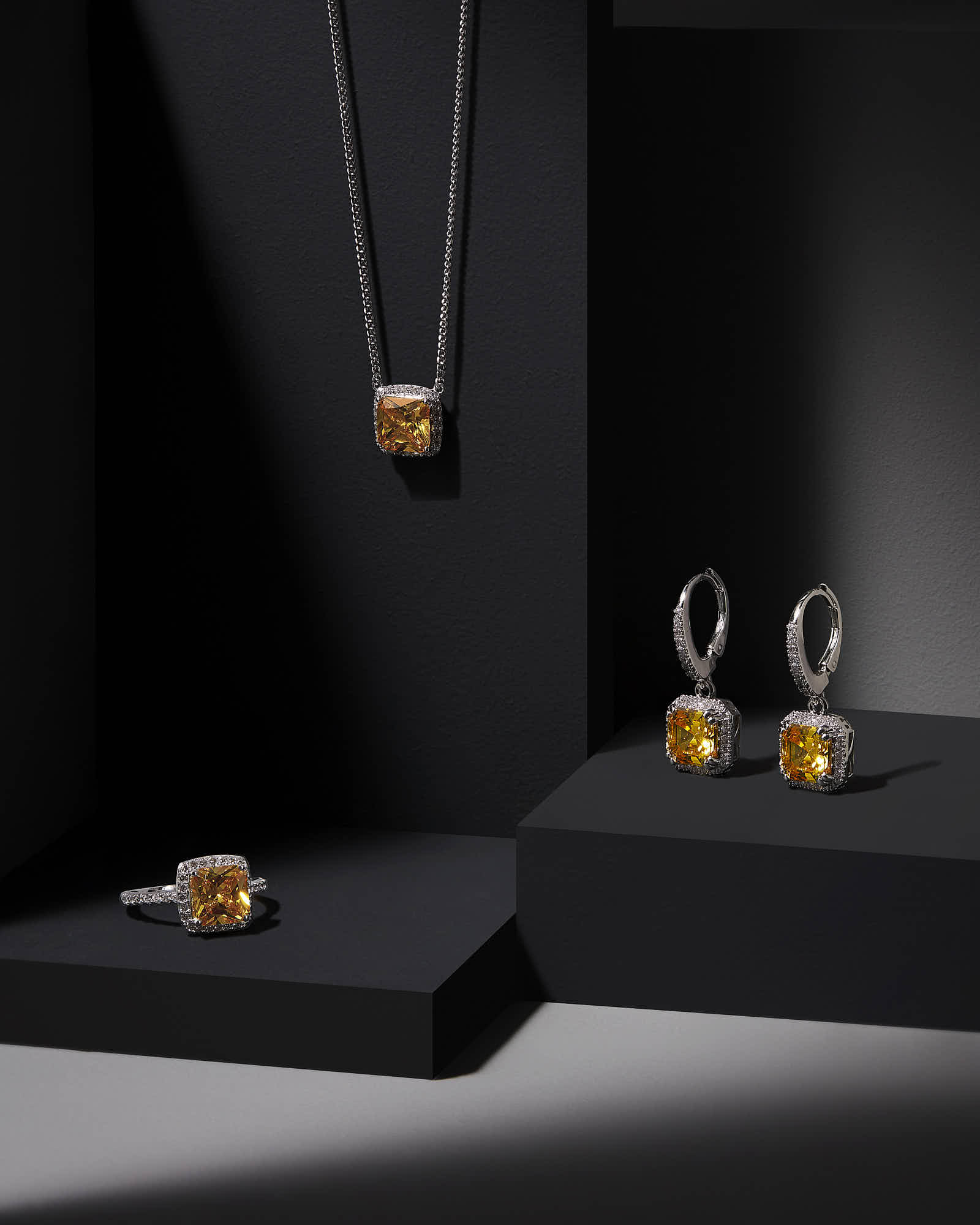 A stylish display of jewelry featuring a necklace and matching earrings on dark surfaces.